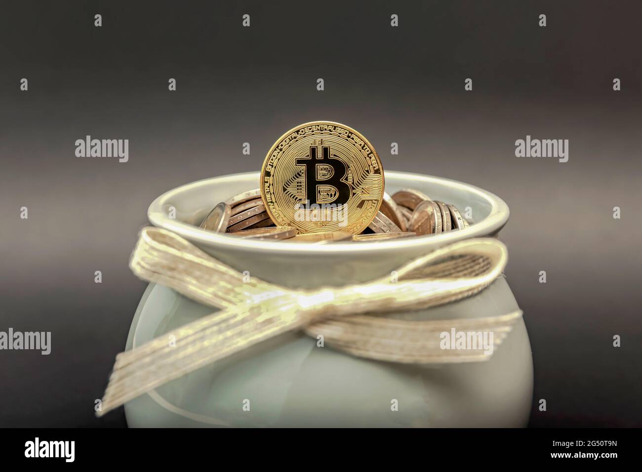La moneta di bitcoin si trova nella banca del piggy sulle monete fiat. Simbolo di accumulo e investimento della criptovaluta Foto Stock