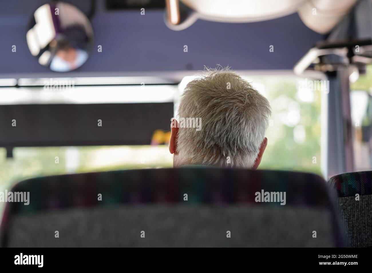 Anziano uomo anziano che viaggia su autobus, vista da dietro il dettaglio solo alla sua testa grigia capelli Foto Stock