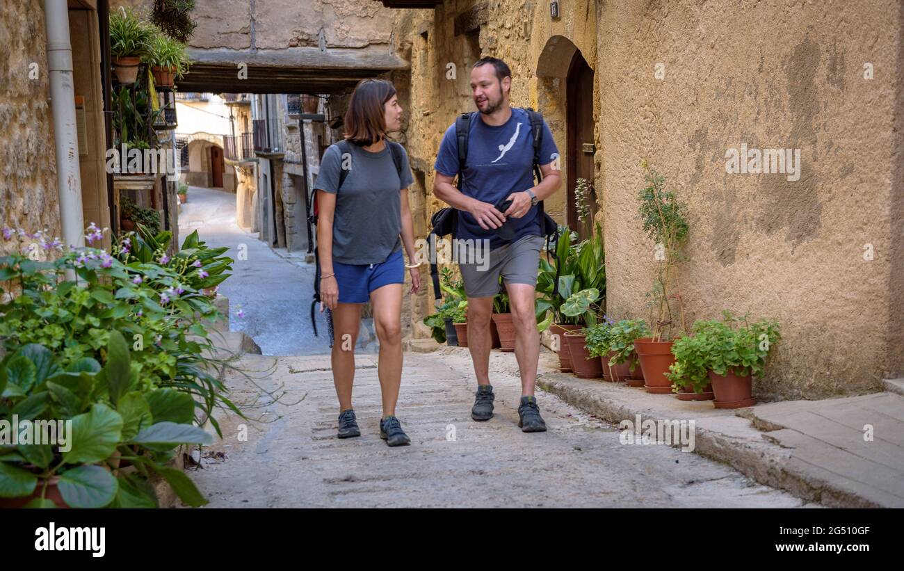 Coppia a piedi attraverso il centro storico di Horta de Sant Joan (Tarragona, Catalogna, Spagna) ESP: Pareja paseando por Horta de Sant Joan (Cataluña) Foto Stock