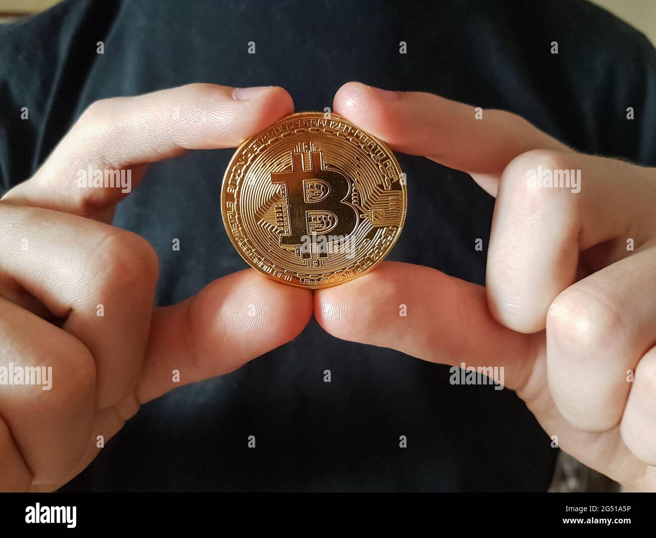 Moneta di pagamento virtuale Bitcoin in mani - primo piano Foto Stock