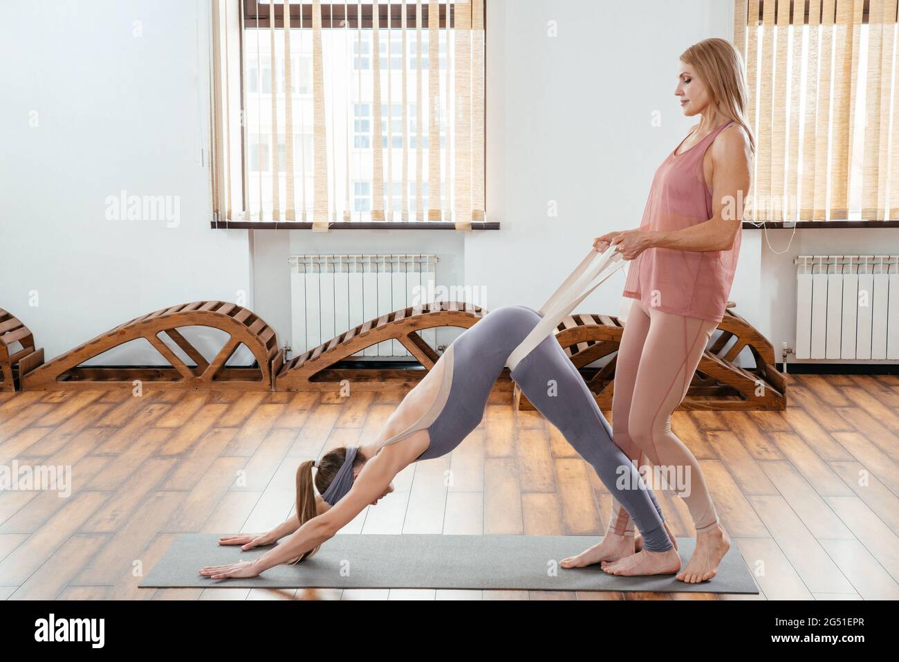 Praticare yoga in studio di yoga insieme. Due amici che fanno yoga in palestra Foto Stock