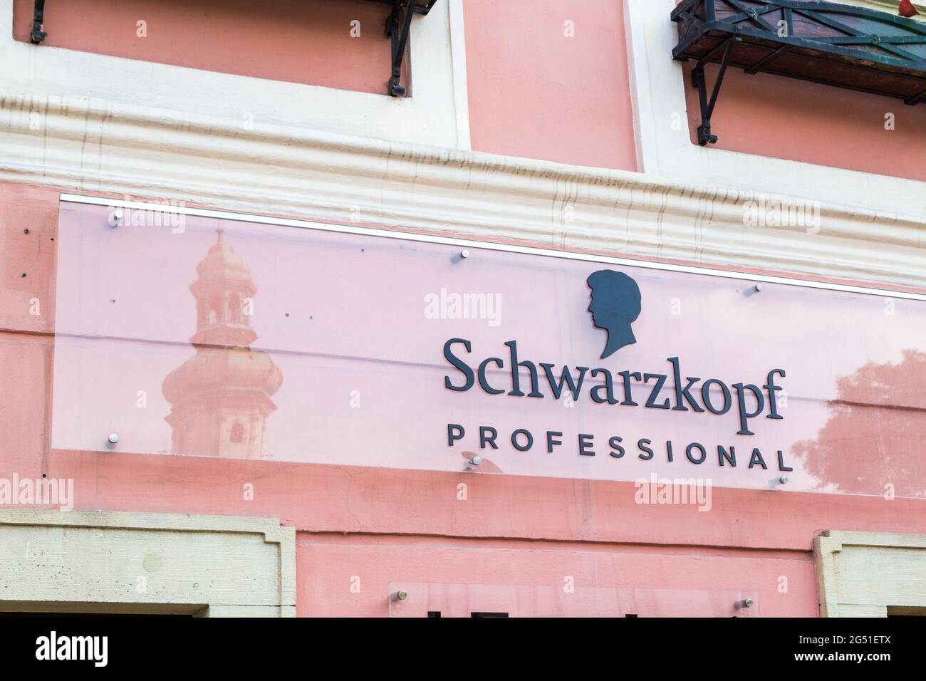 Schwarzkopf professionale parrucchieri segno sul fronte negozio con riflessione di Firewatch Tower (Tuztorony), Sopron, Ungheria Foto Stock
