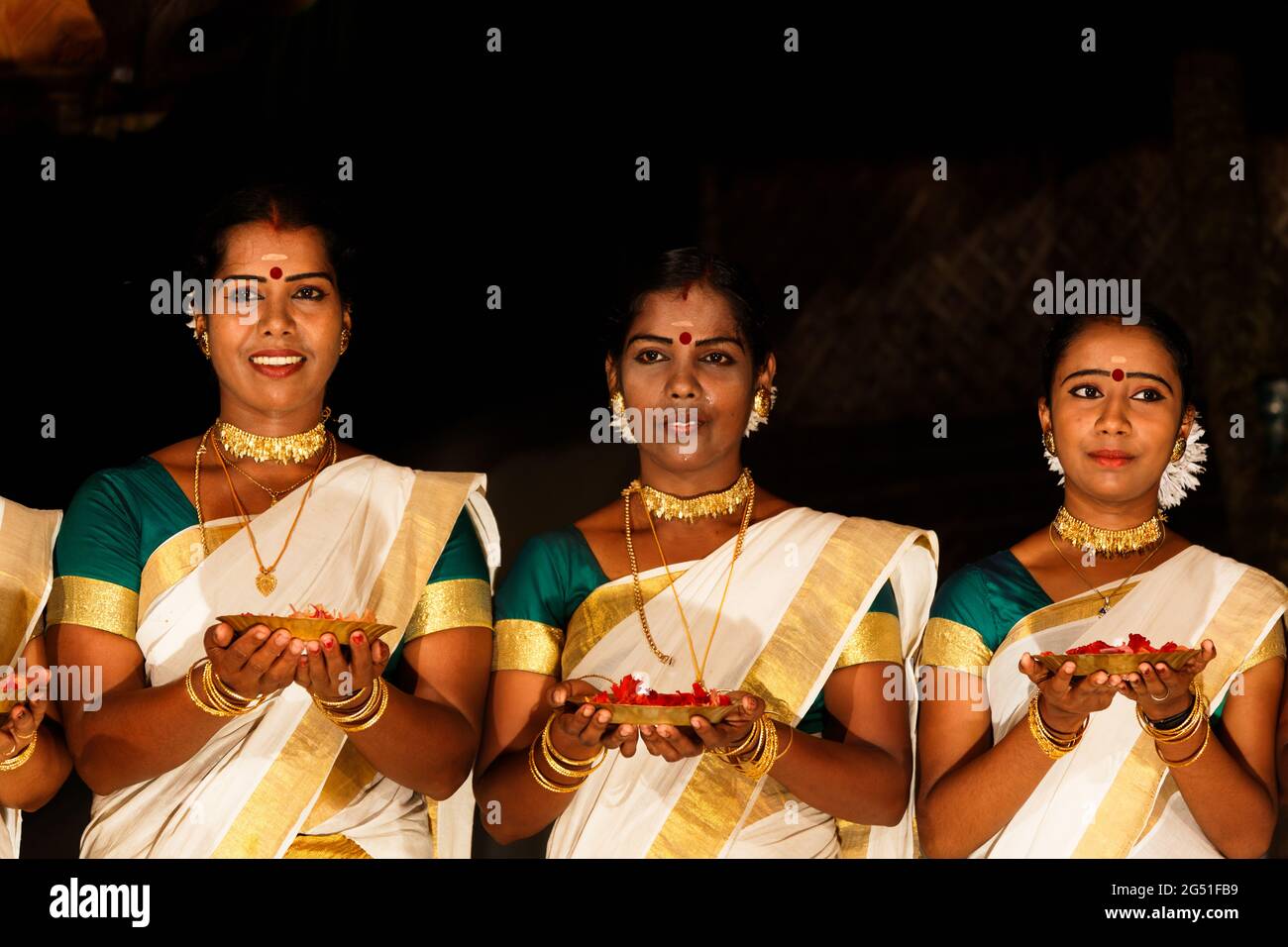 Un'esibizione di danza tradizionale di ballerini in sari sontuosi Foto Stock