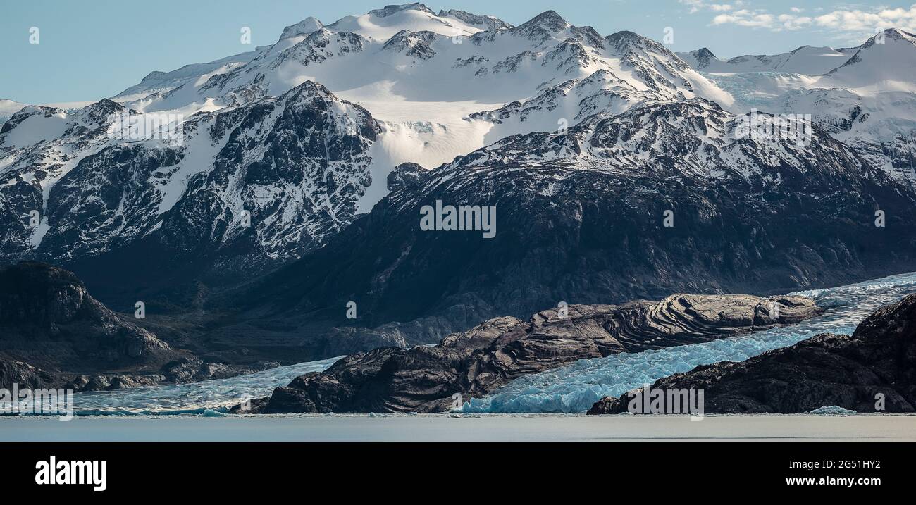 Maestoso paesaggio montano innevato con Ghiacciaio Grey che cade a Lago Grey, Regione Magellanes, Torres del Paine, Cile Foto Stock