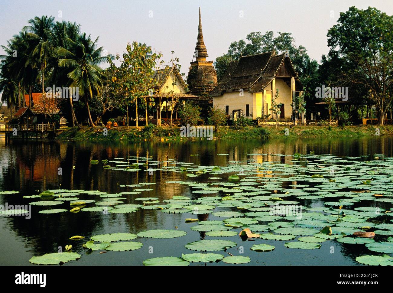 Stagno con ninfee e Tempio di Trafang Thong, Sukhothai Historical Park, Thailandia Foto Stock
