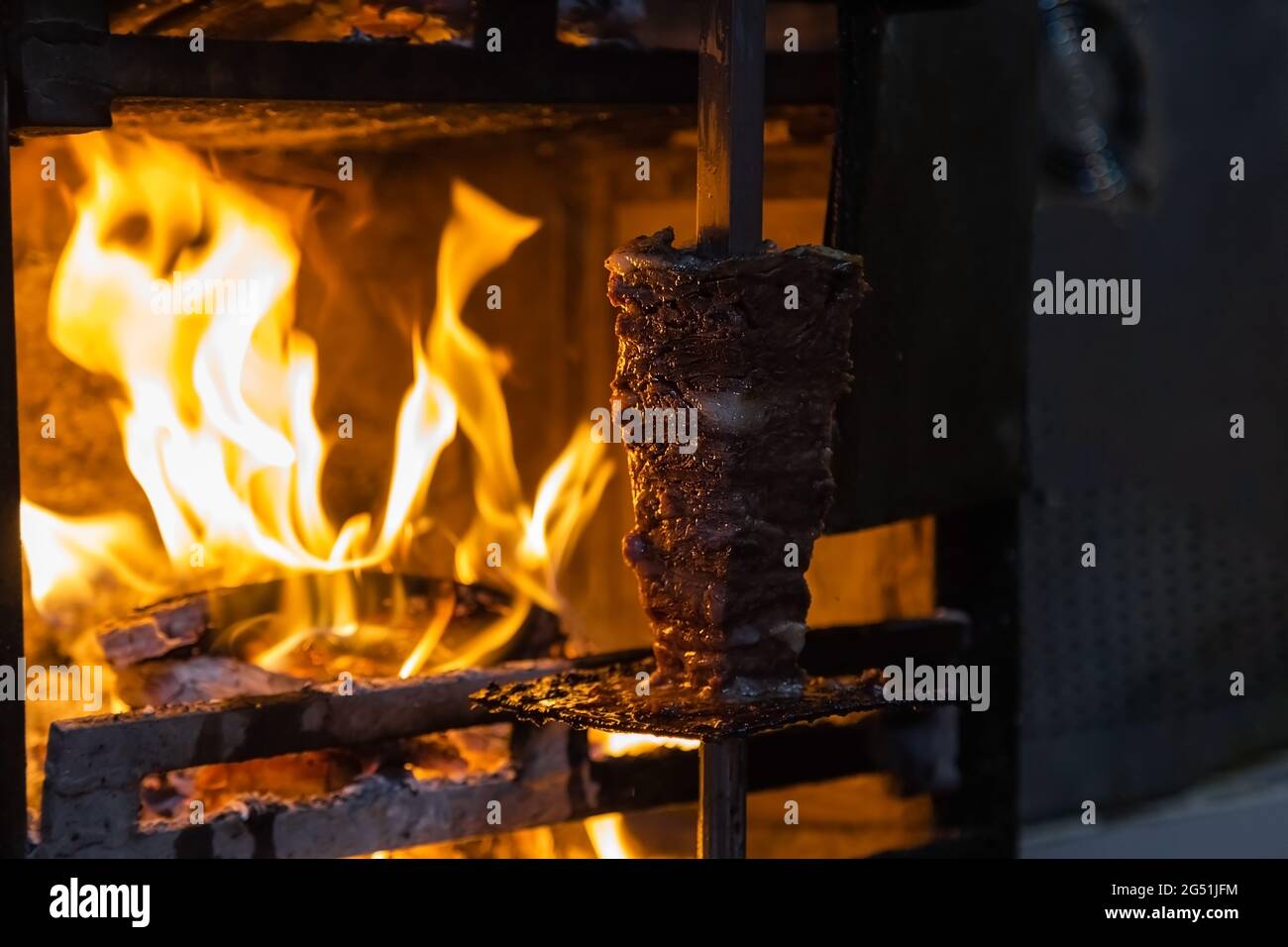 in turchia, la carne per shawarma viene cucinata sul fuoco su uno spiedo, foto notturna. Foto Stock