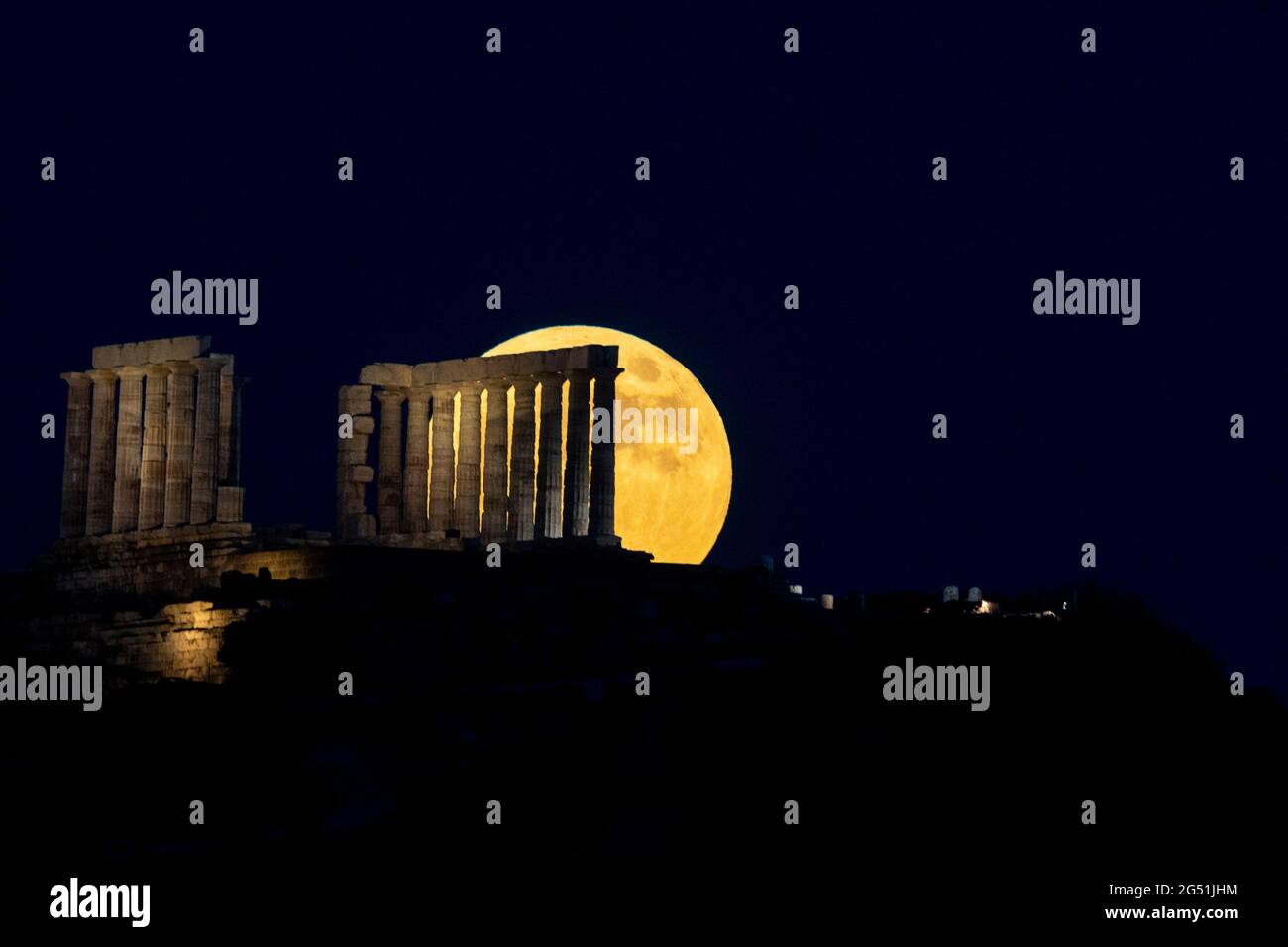 Atene, Grecia. 24 giugno 2021. La luna piena sorge sul Tempio di Poseidone a Capo Sounion, a circa 70 km a sud-est da Atene, Grecia. ©Elias Verdi/Alamy Live News Foto Stock