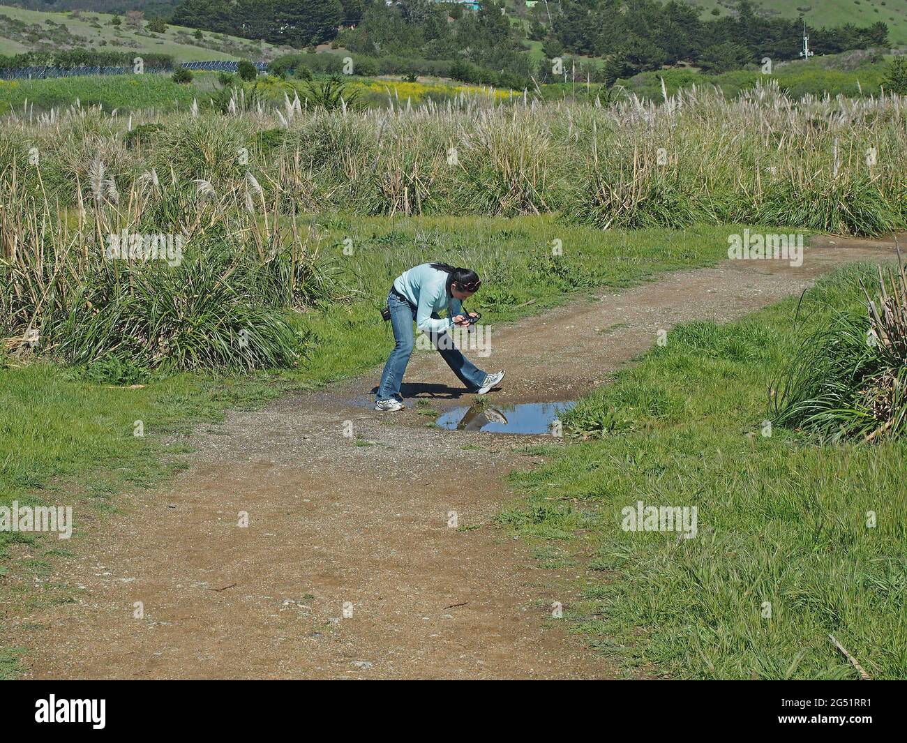 Giovane donna che scatta foto su un sentiero a pacifica, California Foto Stock