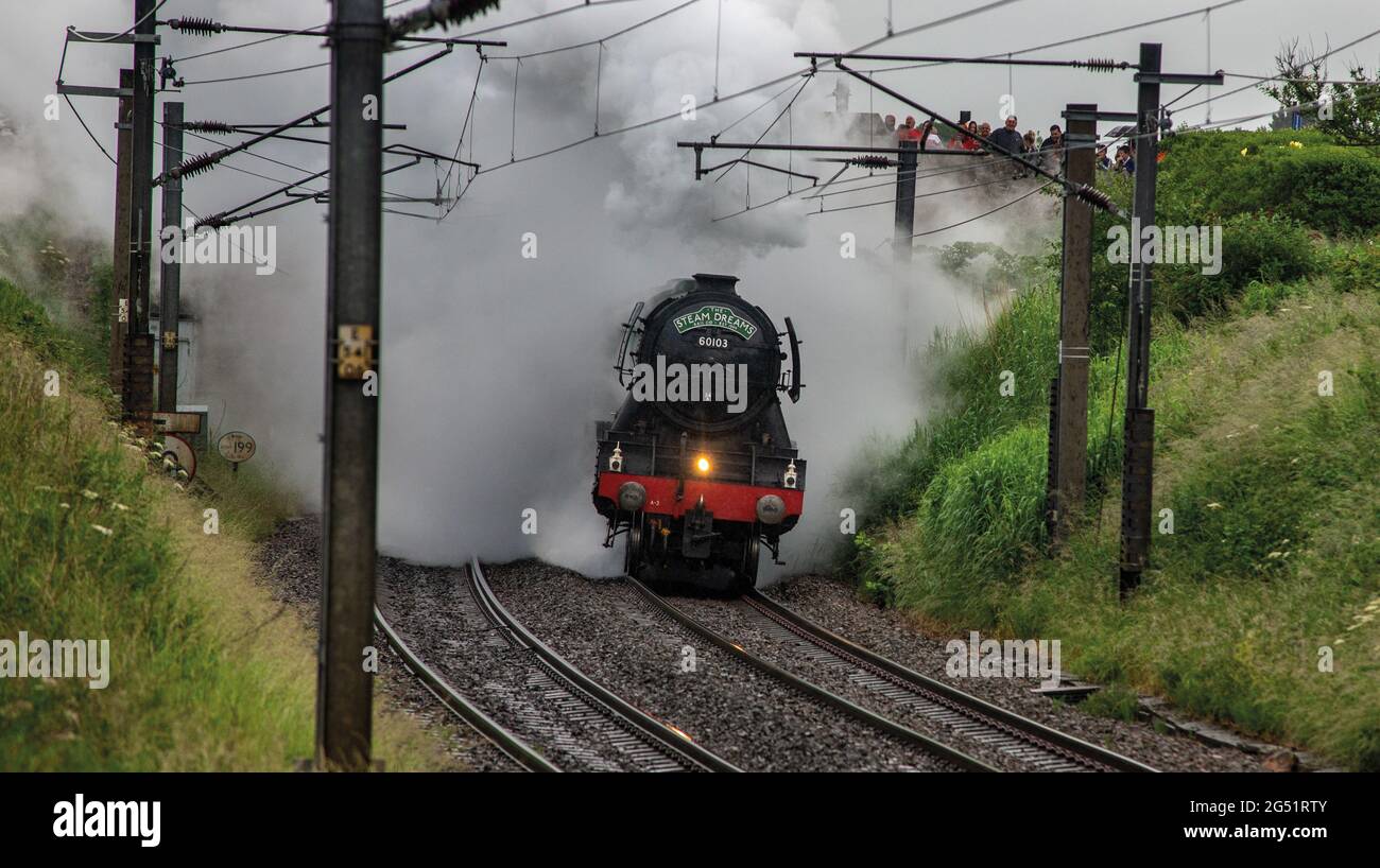 Berwick Upon Tweed, Northumberland, Regno Unito. 24 Giugno 2021. Locomotiva a vapore No.60103 il treno più famoso del mondo il Flying Scotsman si dirige a nord in una serata opaca e umida sulla sua strada per Edimburgo con un'escursione dalla Steam Dreams Rail Company. Foto Stock