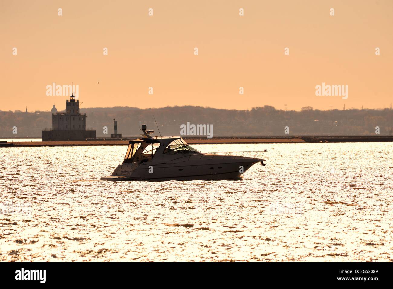 Milwaukee, Wisconsin, Stati Uniti. Un'imbarcazione da diporto entra nel porto di Milwaukee di fronte al faro di Milwaukee Breakwater sul lago Michigan. Foto Stock