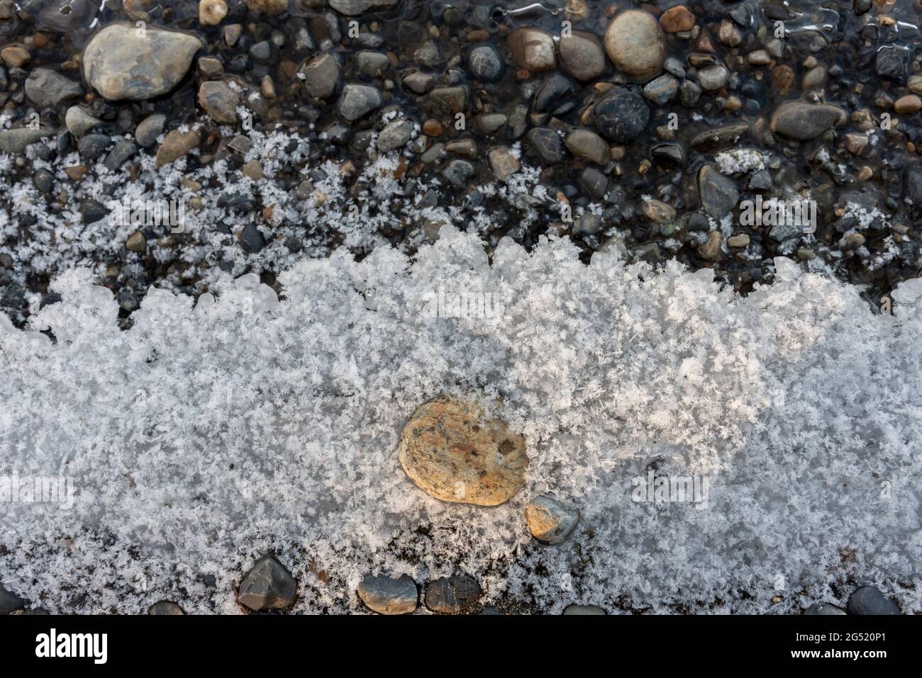 Un ghiaccio, ghiacciato inverno perdita costa con acque cristalline e rocce sotto la costa. Preso nel Canada del nord durante la stagione fredda gelida. Foto Stock