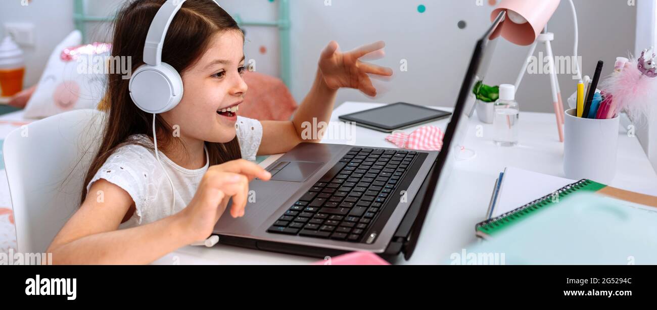 Ragazza che studia da casa con un computer portatile Foto Stock