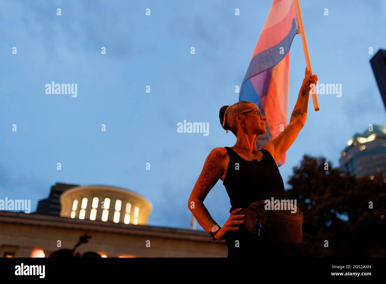 Cole Ramsey, 39 anni, di South Linden detiene una Bandiera di Pride di Transgender davanti allo Stato dell'Ohio per protestare contro il passaggio della legislazione contro le Trans Women che giocano a sport nelle scuole superiori e nel college. I sostenitori dei diritti transgender si sono levati al di fuori della Ohio Statehouse per opporsi e richiamare l'attenzione su un emendamento a un disegno di legge che proibirebbe alle donne transgender di partecipare alle scuole superiori e agli sport femminili universitari. Il disegno di legge originale che questo divieto di transgender è stato aggiunto a trattare con la compensazione per gli studenti universitari di trarre profitto dal loro nome, immagine e somiglianza. L'aggiunta del divieto di transgender a t Foto Stock