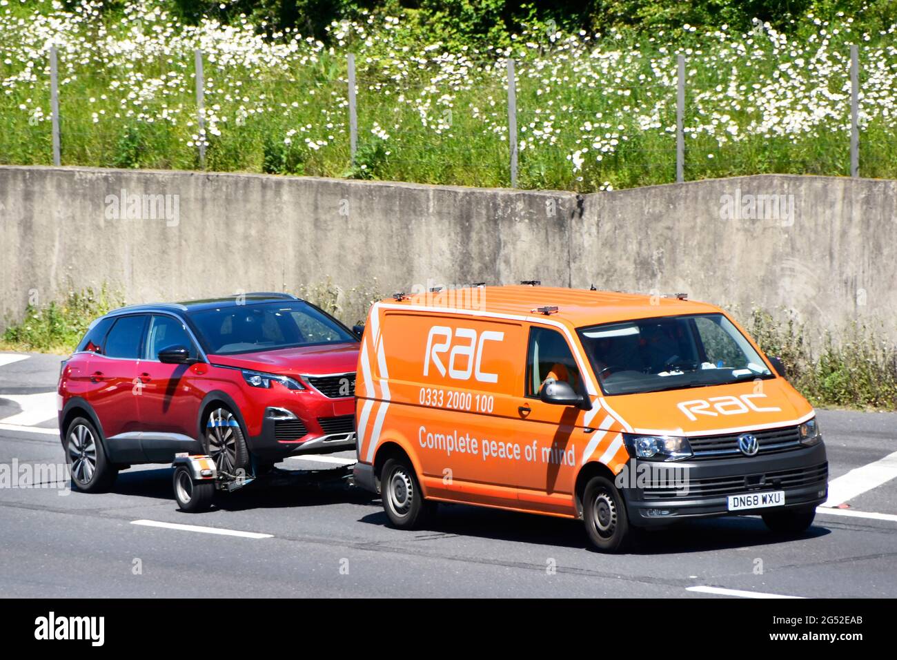 RAC VW van training Peugeot auto per il servizio di recupero guasti o trasporto di consegna auto con una completa tranquillità di business slogan autostrada UK Foto Stock