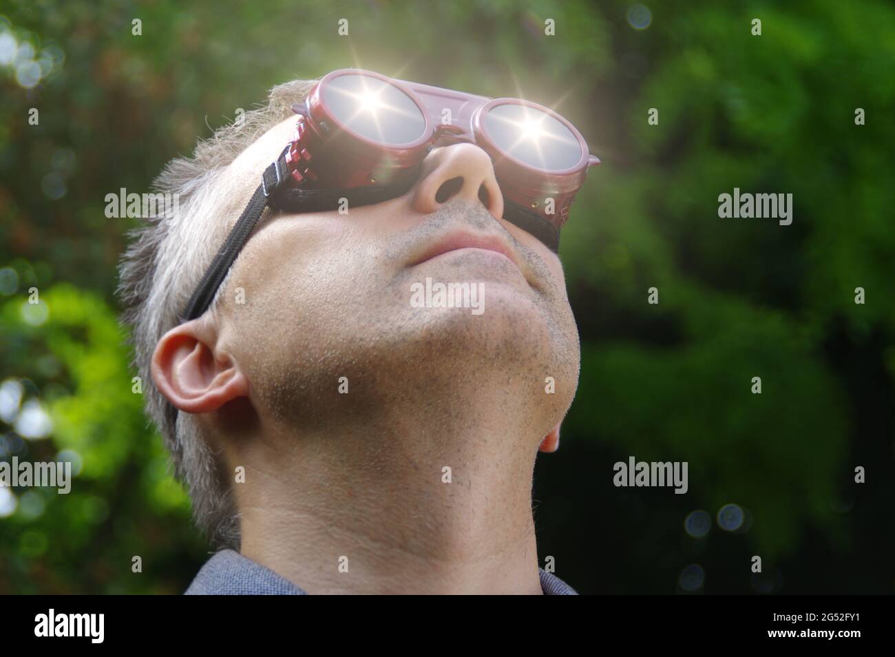 Uomo che guarda un'eclissi del sole attraverso gli occhiali di sicurezza. Guardando al fenomeno solare. Foto Stock