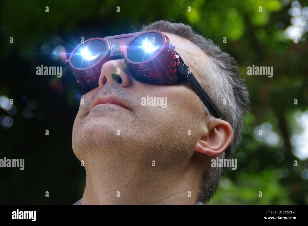 Uomo che guarda un'eclissi del sole attraverso gli occhiali di sicurezza. Guardando  al fenomeno solare Foto stock - Alamy