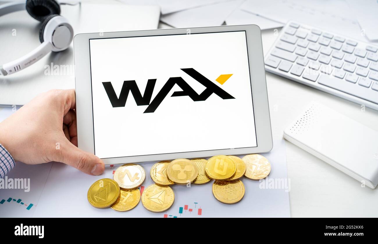 Russia Mosca 06.05.2021.Man compressa da tenere con logo di token, CERA criptovaluta. Moneta Crypto per l'estrazione in gioco online, piattaforme di gioco Alien World Foto Stock