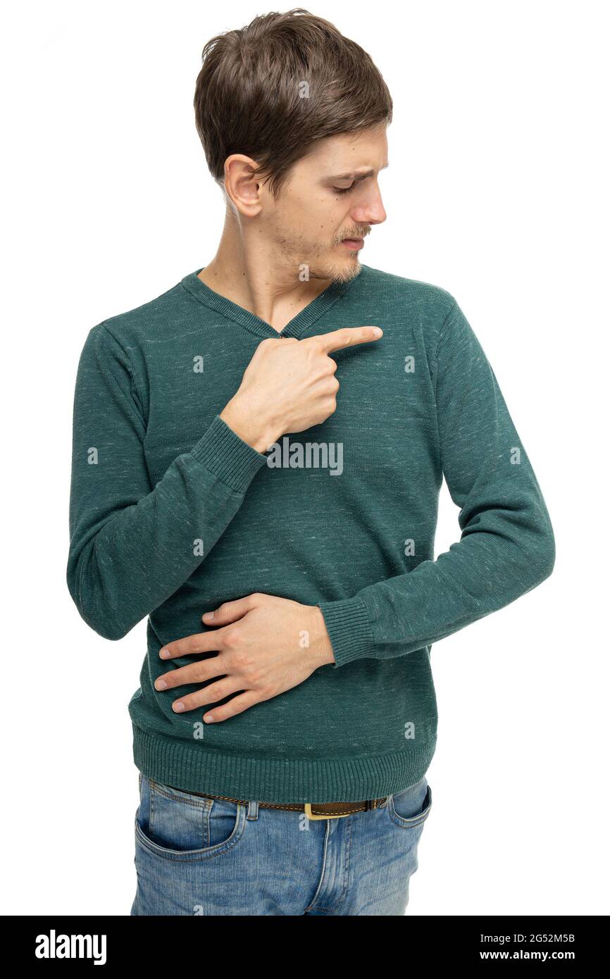 Giovane bell'uomo bianco alto e sottile con capelli marroni che puntano alla spalla in un pullover verde scuro in jeans blu isolato su sfondo bianco Foto Stock