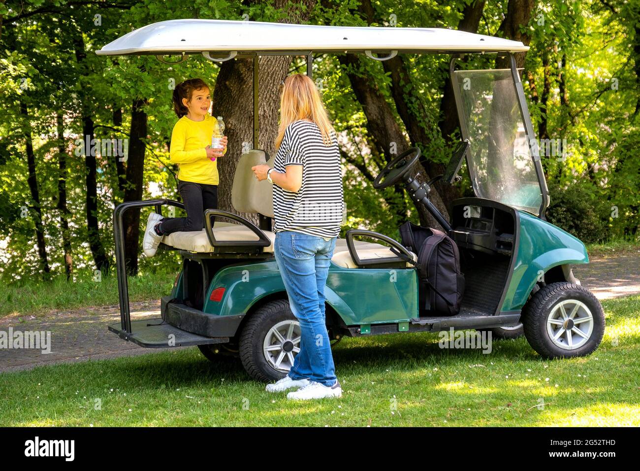 golf cart famiglia verde buggy con madre e bambino in vacanza sul campo da golf Foto Stock