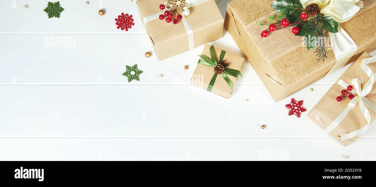Banner di Natale con bordo di scatole regalo su sfondo di legno bianco Foto Stock