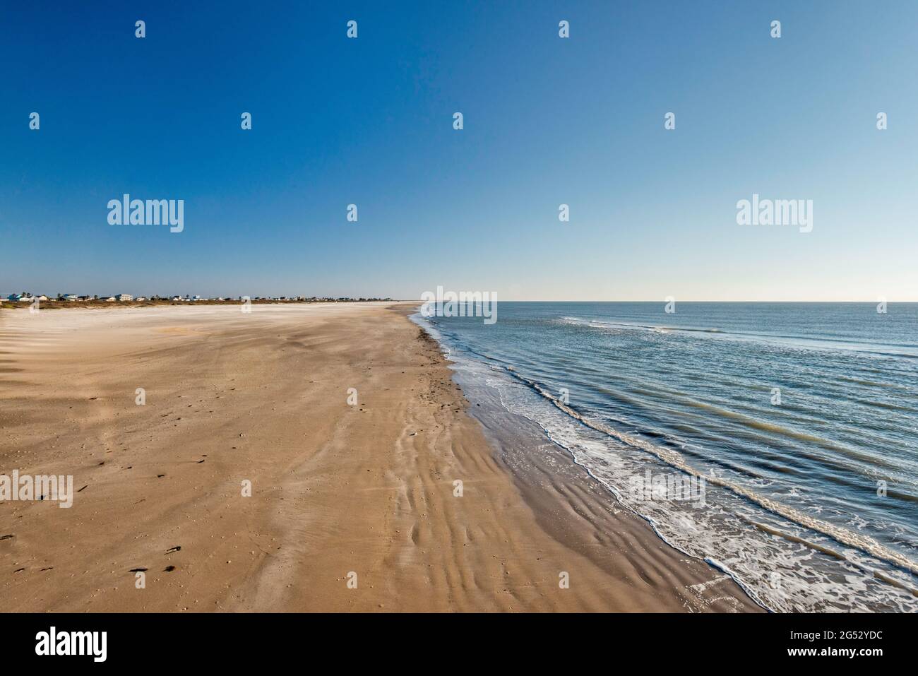 Vista della spiaggia dal molo sulla penisola di Matagorda vicino alla foce del fiume Colorado nel Golfo del Messico, vicino a Matagorda, Texas, Stati Uniti Foto Stock