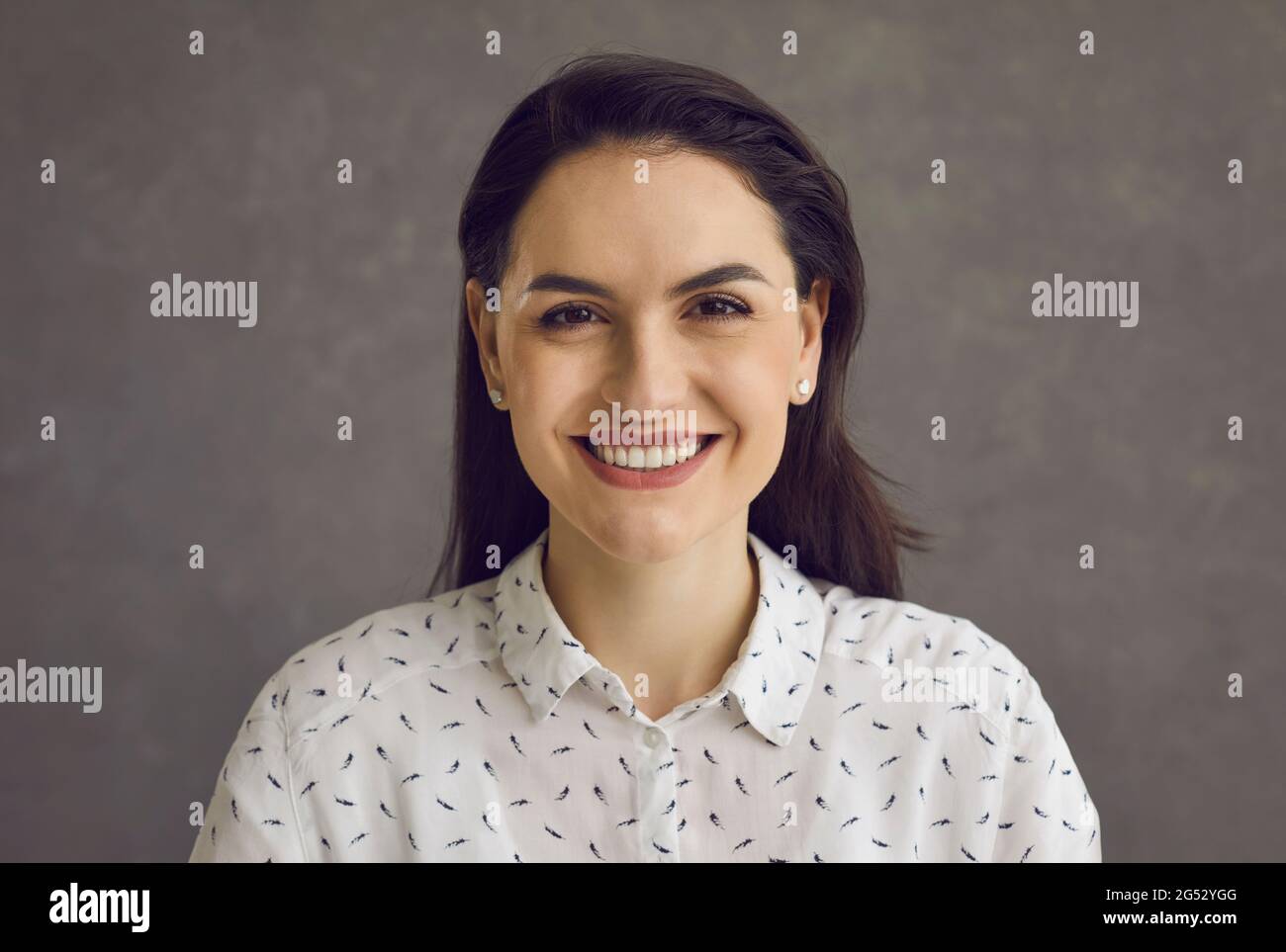 Giovane donna sorridente che guarda il ritratto di primo piano di studio della fotocamera Foto Stock