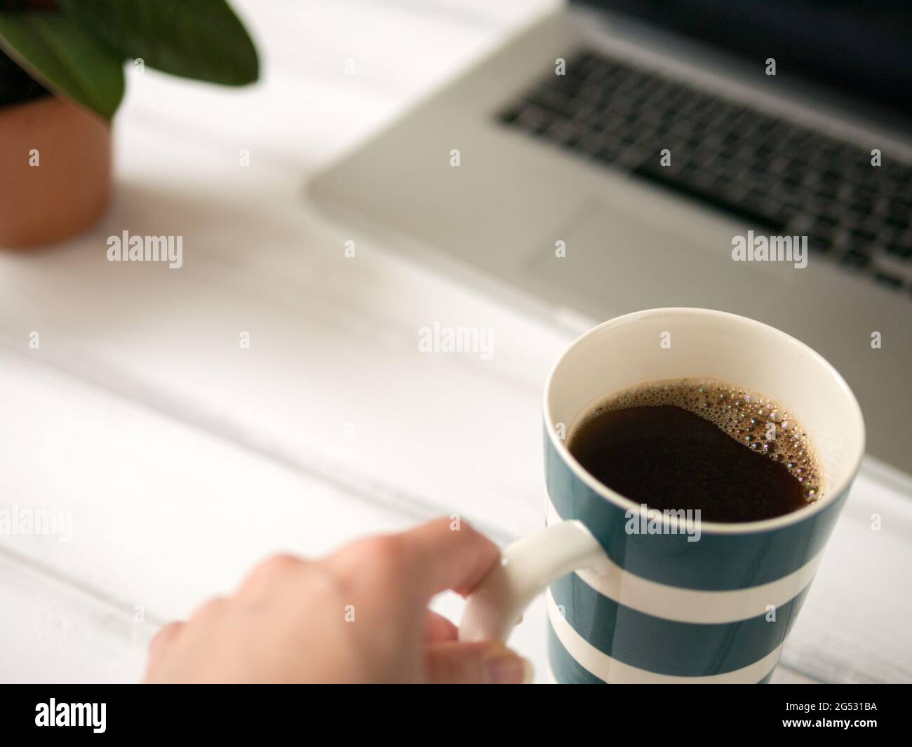 La mano tocca la tazza grande di caffè Foto Stock