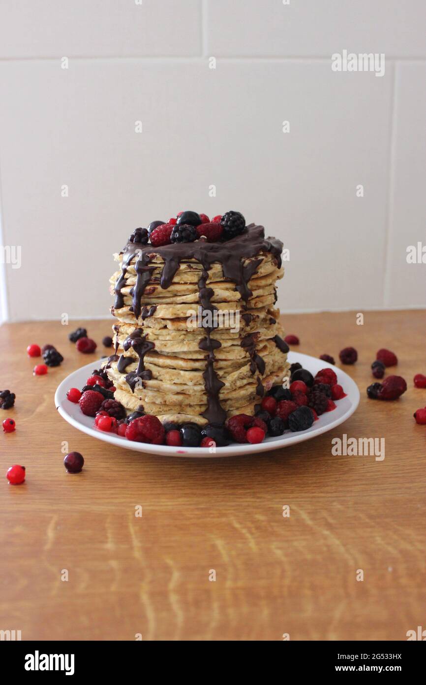 Torre dei pancake con cioccolato e frutta rossa Foto Stock