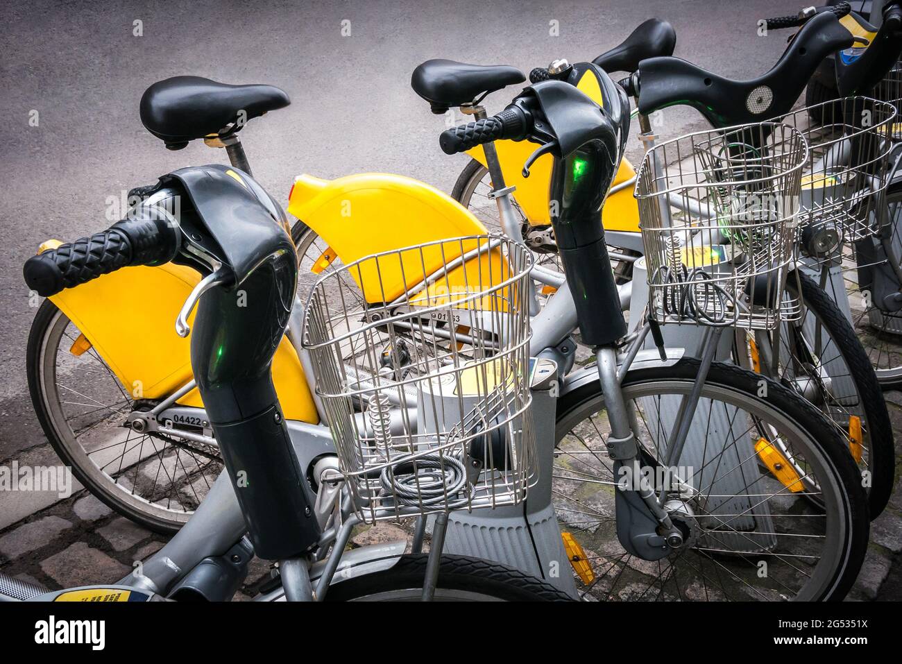 La fila di biciclette gialle della città parcheggiate Foto Stock