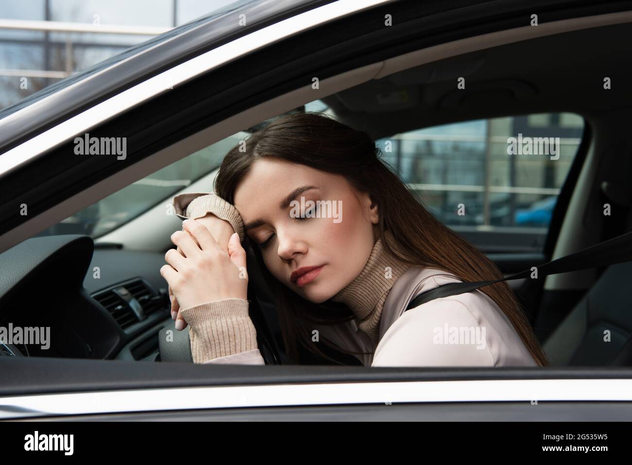 giovane donna esausta che dorme in auto al volante Foto stock - Alamy
