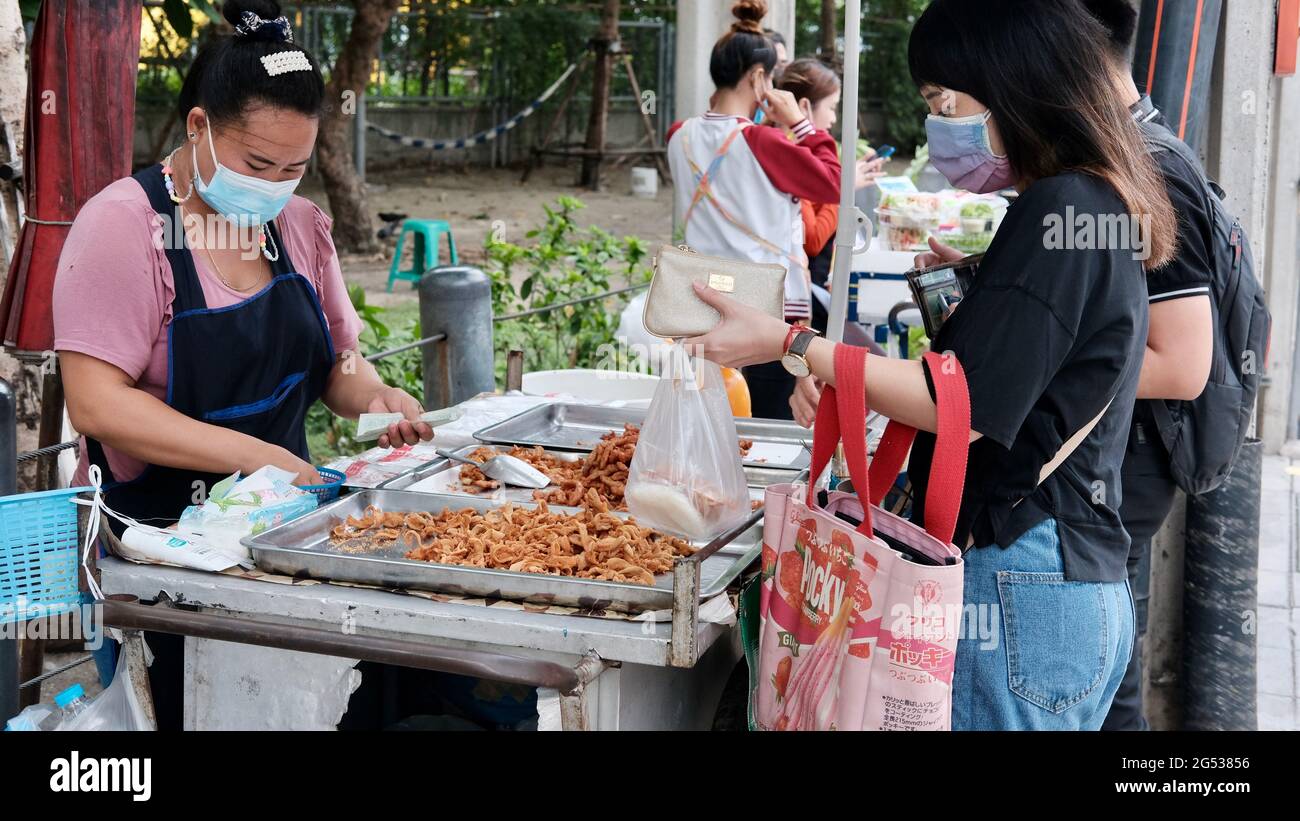 Compratore e venditore soldi autentici che cambiano le mani Klong Toey mercato BangkokThailandia l'economia delle vendite di cibo gente che compra il pranzo Rama 4 intersezione Foto Stock