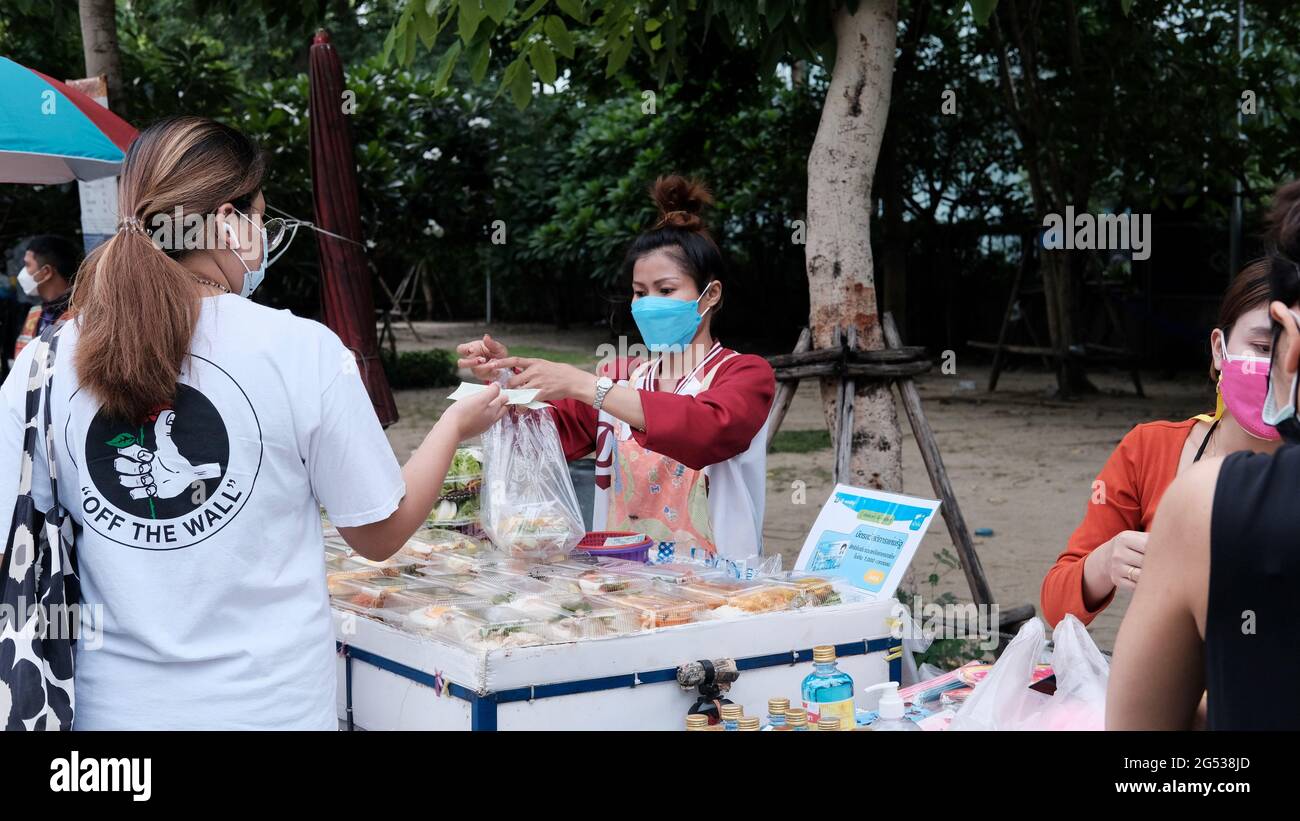 Compratore e venditore soldi autentici che cambiano le mani Klong Toey mercato BangkokThailandia l'economia delle vendite di cibo gente che compra il pranzo Rama 4 intersezione Foto Stock