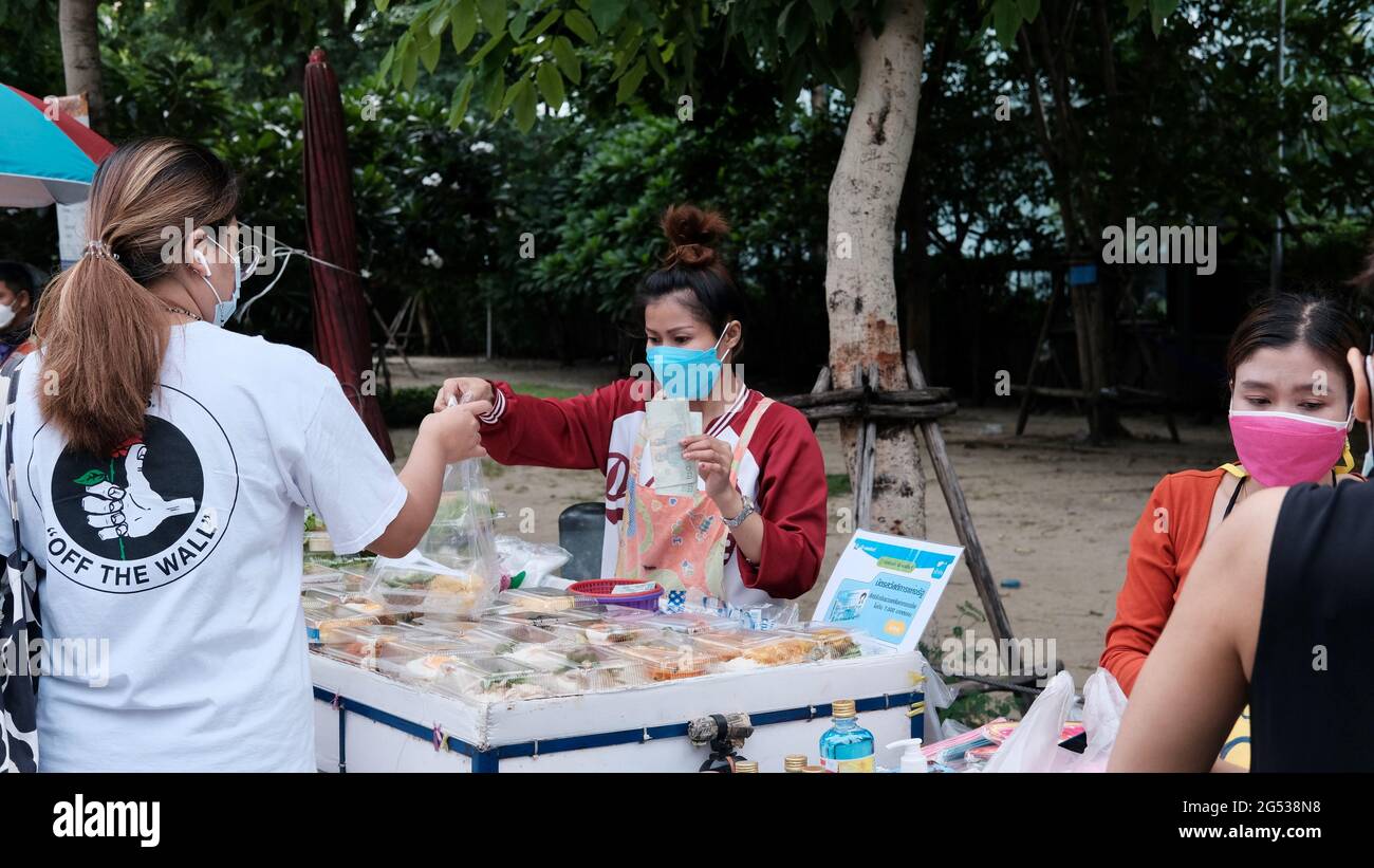 Compratore e venditore soldi autentici che cambiano le mani Klong Toey mercato BangkokThailandia l'economia delle vendite di cibo gente che compra il pranzo Rama 4 intersezione Foto Stock