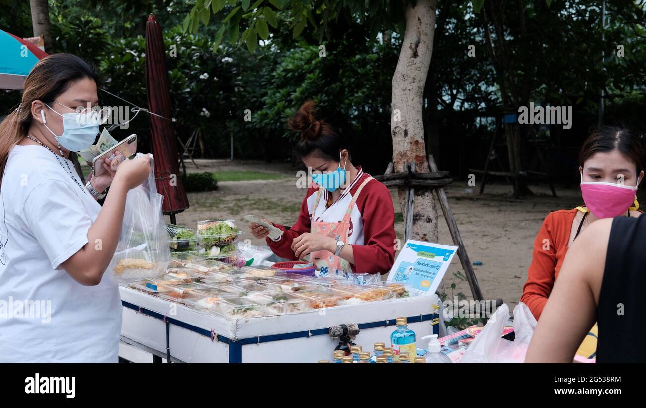 Compratore e venditore soldi autentici che cambiano le mani Klong Toey mercato BangkokThailandia l'economia delle vendite di cibo gente che compra il pranzo Rama 4 intersezione Foto Stock
