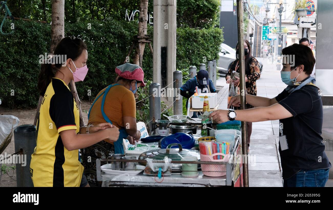 Compratore e venditore soldi autentici che cambiano le mani Klong Toey mercato BangkokThailandia l'economia delle vendite di cibo gente che compra il pranzo Rama 4 intersezione Foto Stock