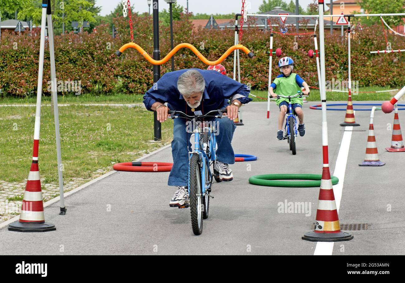 Nonni che insegnano ai bambini le regole della bicicletta, a Civitas Vitae, residenza per anziani, a Padova, Italia Foto Stock