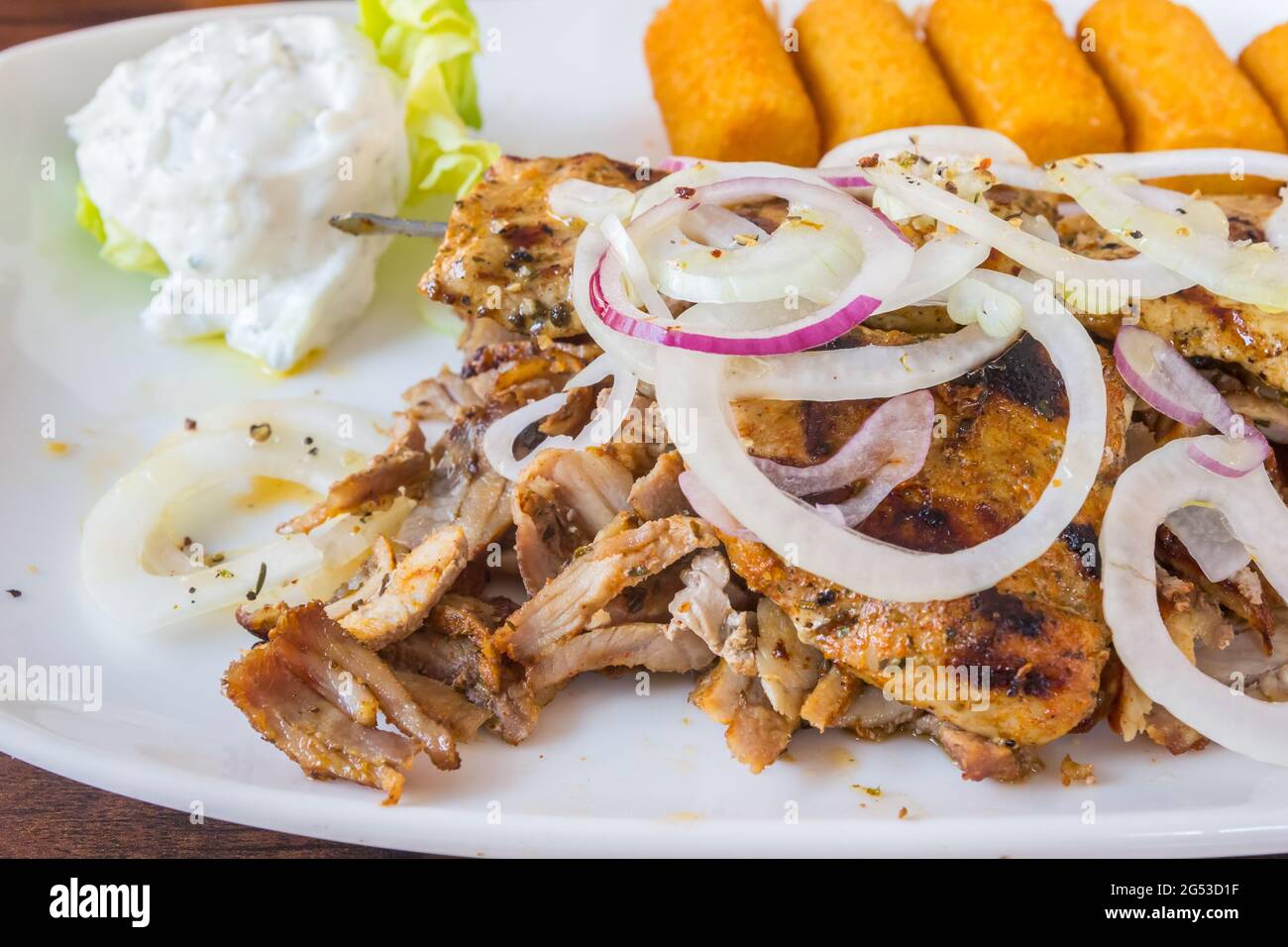 Piatto di carne greca in stile tedesco servito con gyros, souflaki, souzouki, crocchette di patate e tzatziki Foto Stock