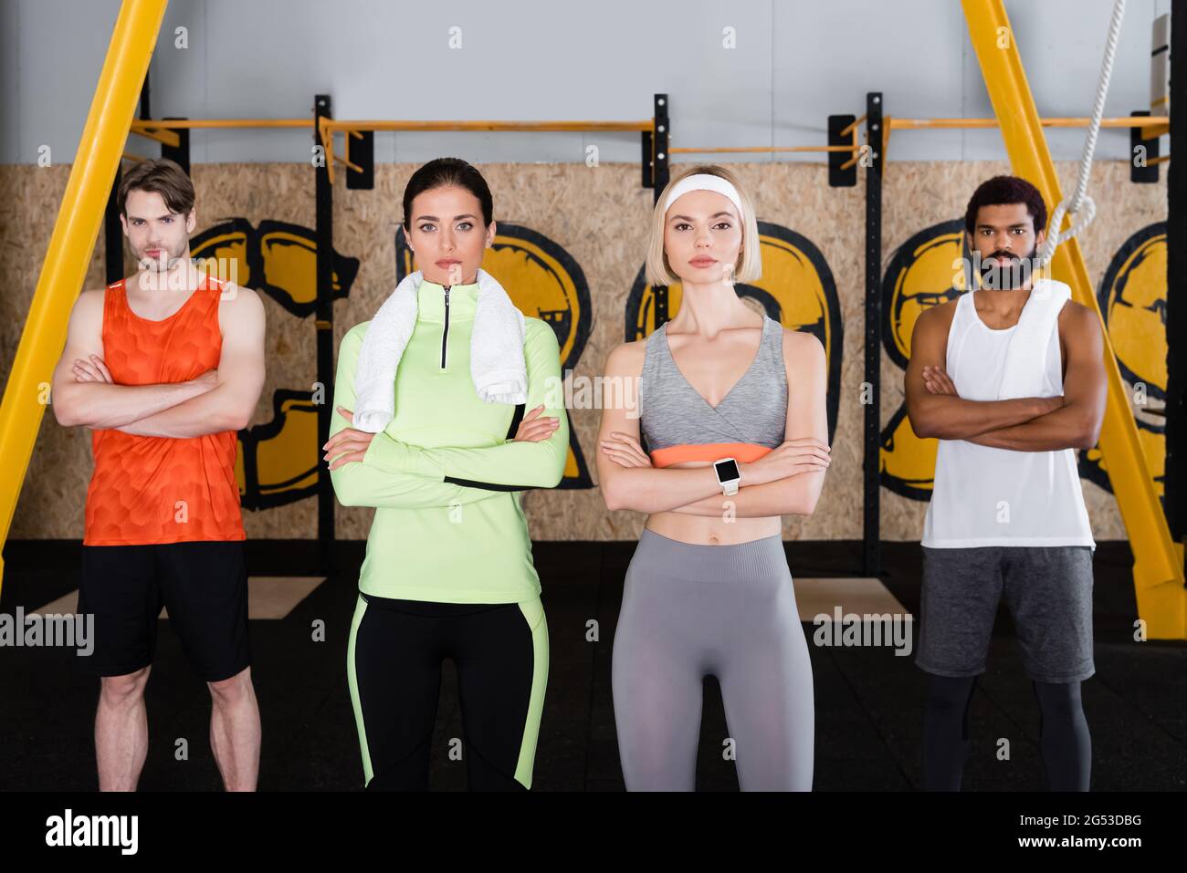 vista frontale di sportivi multiculturali che guardano alla macchina fotografica nel centro fitness Foto Stock