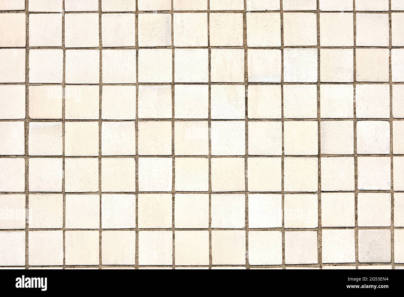 Sfondo da una parete fatta di tessere mosaico quadrate beige Foto Stock