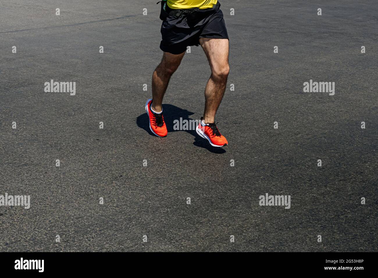 uomo runner gambe in scarpe arancioni che corre su strada buia Foto Stock