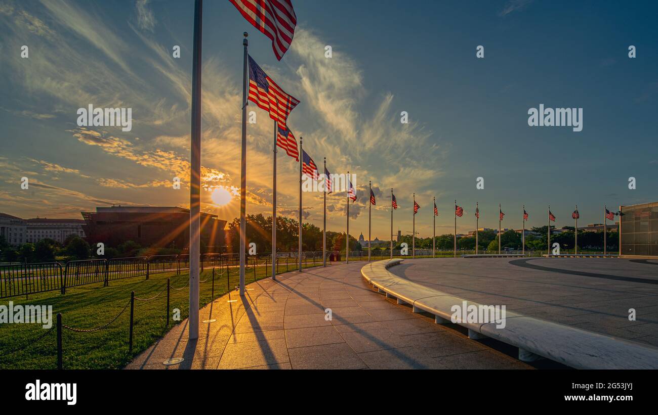 Alba sul ring delle bandiere americane intorno al Washington Monument nel campidoglio degli Stati Uniti con il centro commerciale nazionale e i musei Smithsonian sullo sfondo. Foto Stock