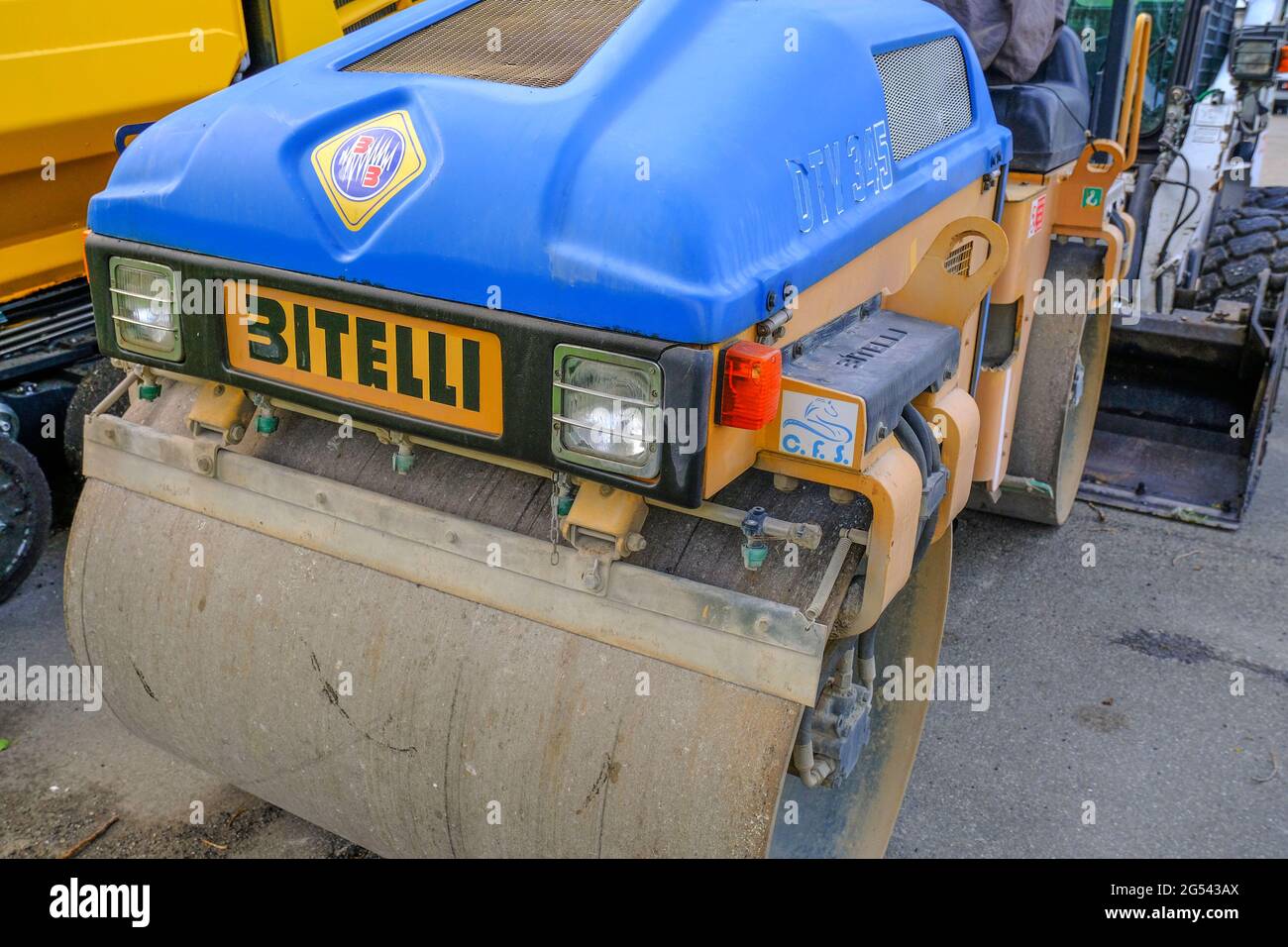 Maggio 2021 Parma, Italia: Asfaltatrice blu macchina stradale Bitelli parcheggiata su altre macchine industriali pesanti Foto Stock