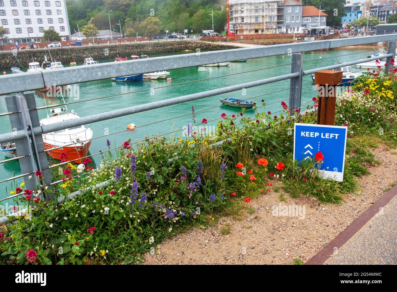 Covid social distancing segno a Folkestone Harbour, con un sistema a senso unico attraverso l'ex ponte ferroviario, Kent, Regno Unito Foto Stock