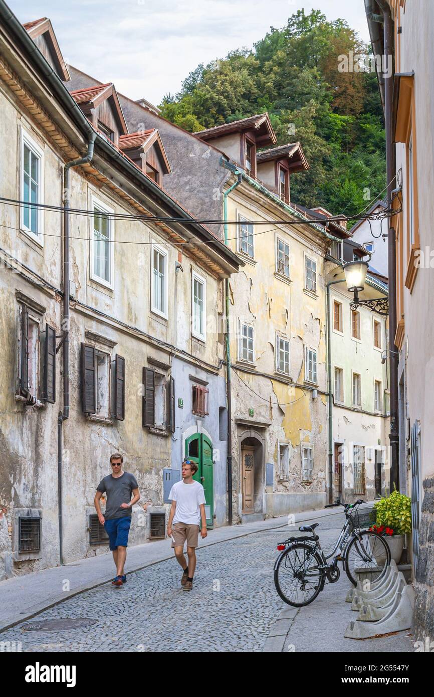 Lubiana, Slovenia - 15 agosto 2018: I giovani turisti camminano lungo una vecchia e pittoresca strada nel pomeriggio nel centro storico Foto Stock