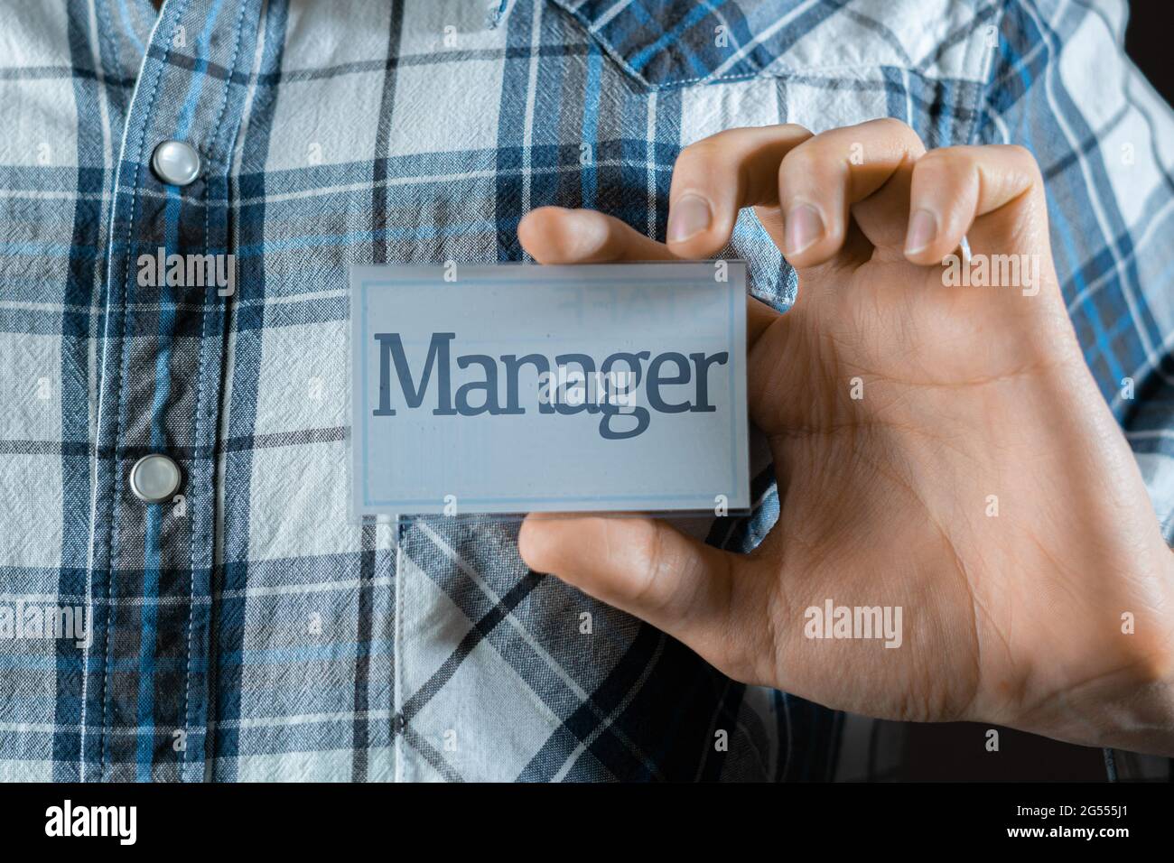 un dipendente maschio che ha un badge con la parola 'magro' sulla sua camicia Foto Stock