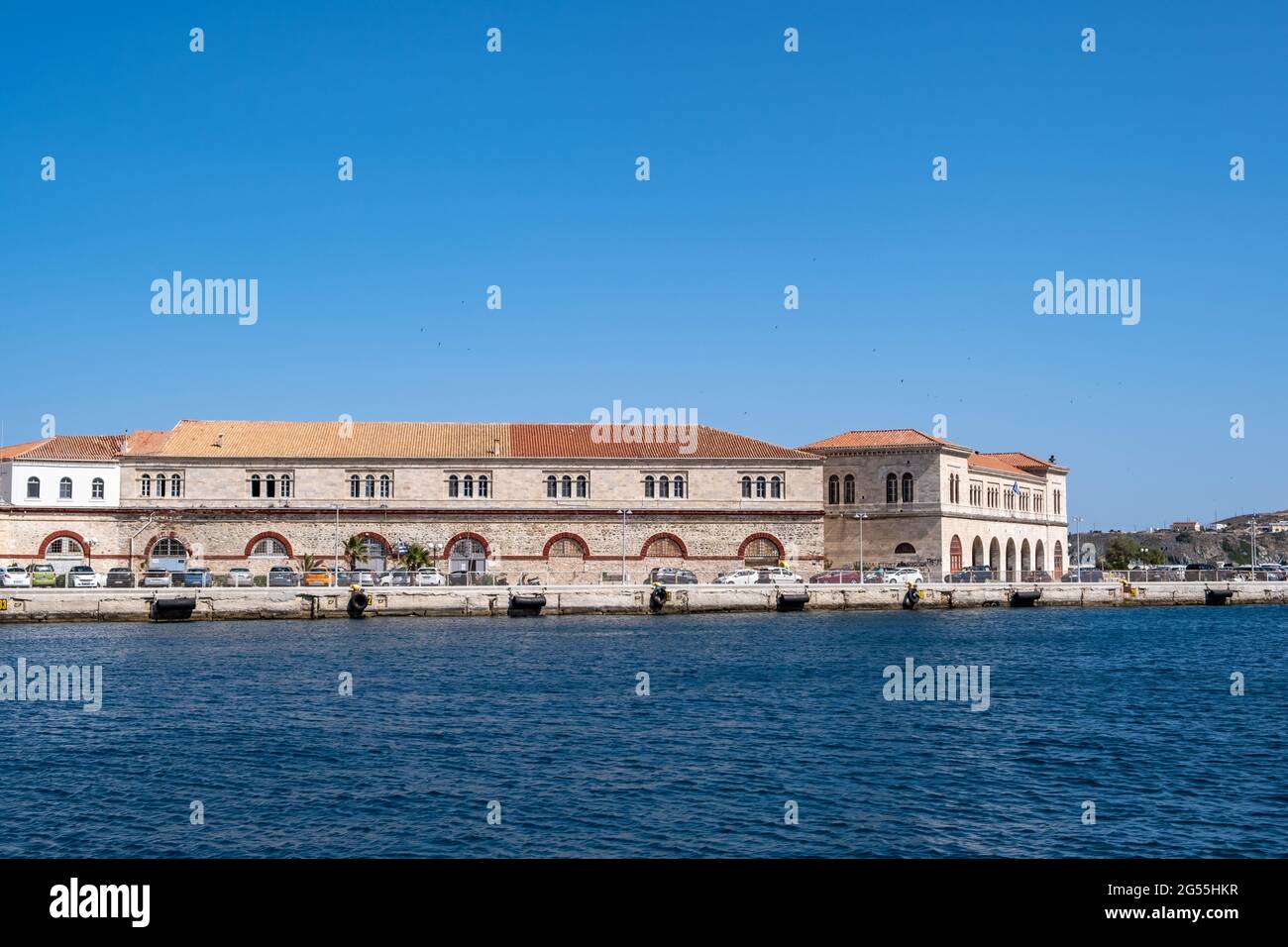 Galleria d'arte costruzione di vecchi magazzini di transito al porto di Hermoupolis, isola di Syros, Cicladi, Grecia. Stonewall edificio tradizionale con tetto piastrellato. Estate des Foto Stock
