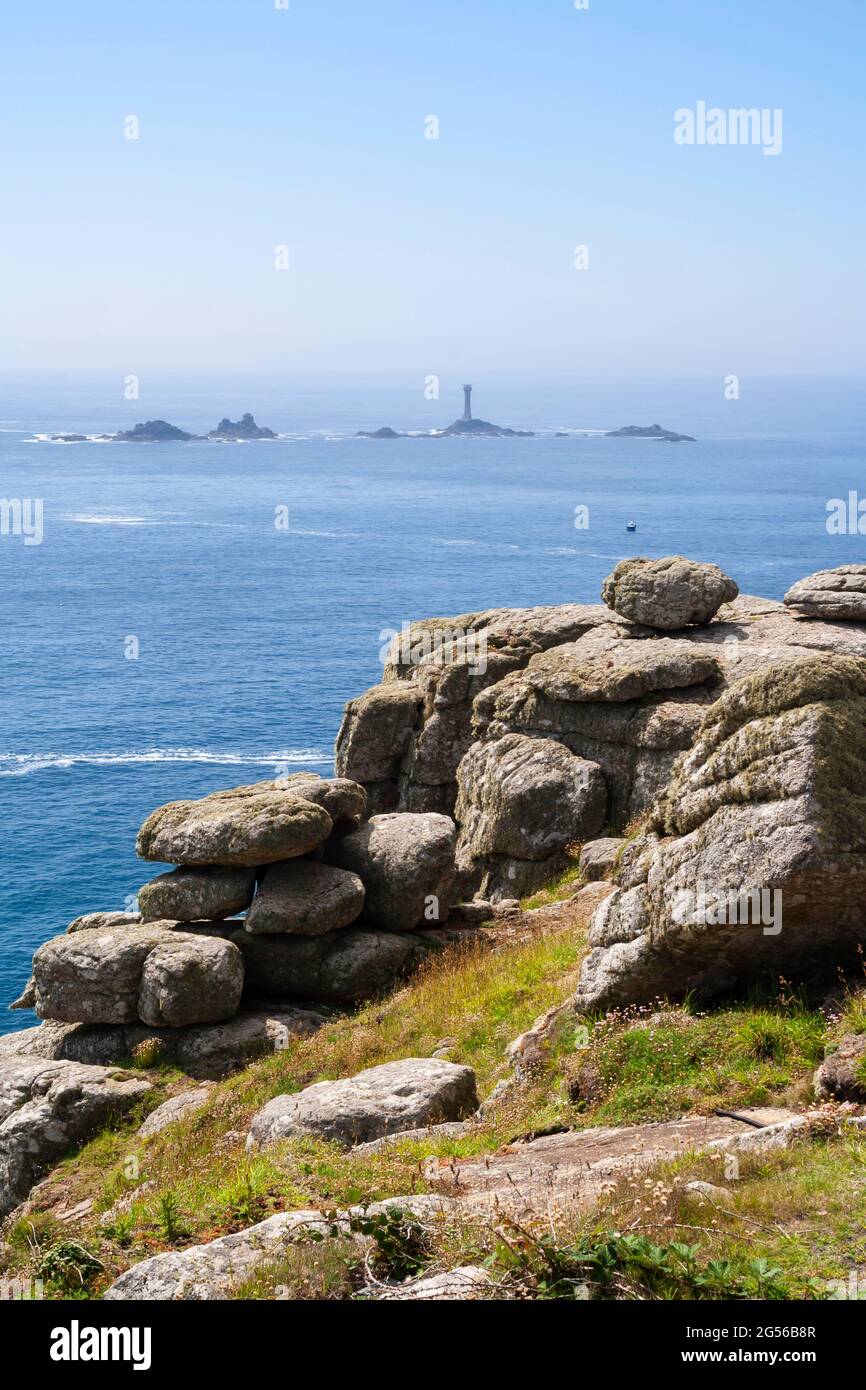 Vista sul mare degli isolotti e delle navi da palangari Faro, noto anche come Wolf Rock Lighthouse, alla fine di Land in Cornovaglia (Regno Unito) Foto Stock
