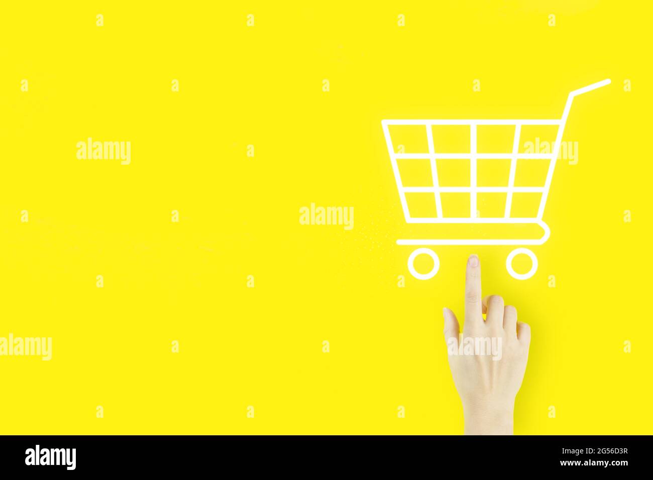 Online shopping business concetto selezione carrello. Mano di giovane donna che punta con ologramma Carrello su sfondo giallo. Digitale Foto Stock