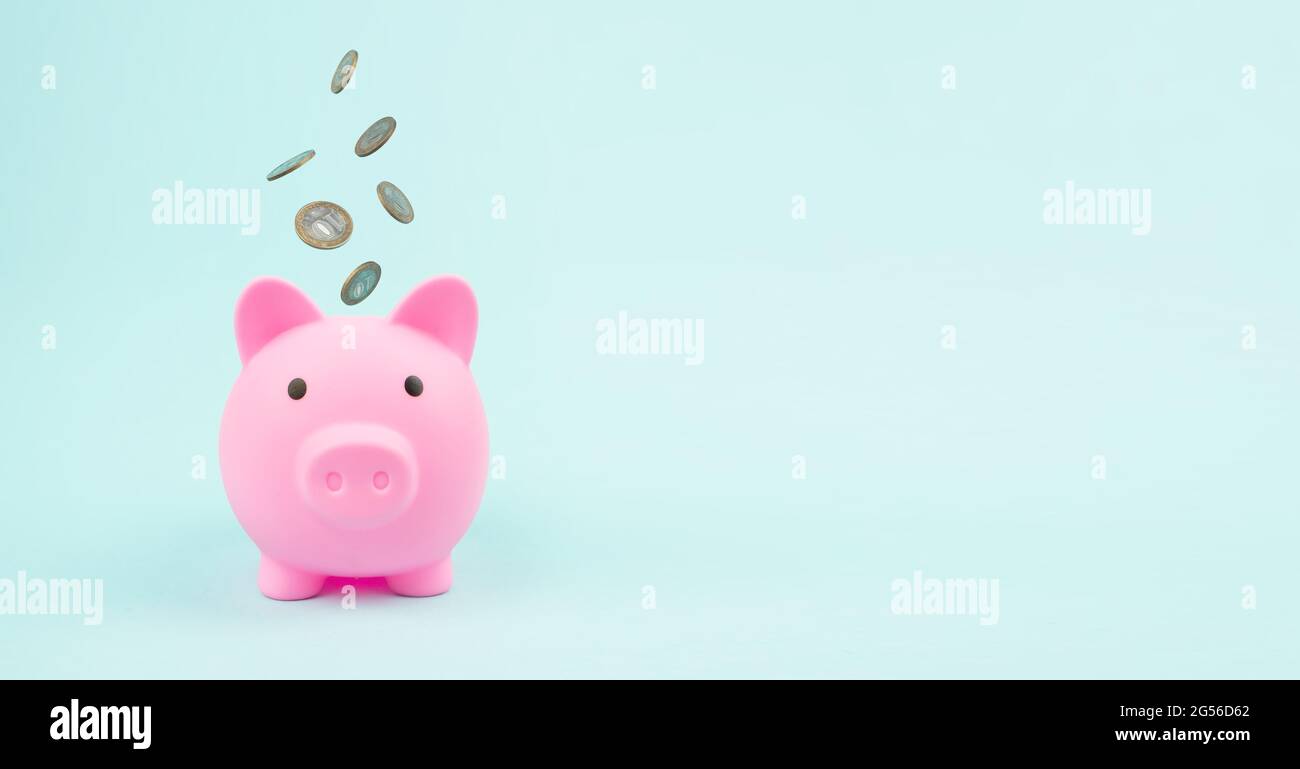 Pink Piggy Bank con monete in caduta, concetto di risparmio. Risparmio finanziario ed economia bancaria. Foto Stock