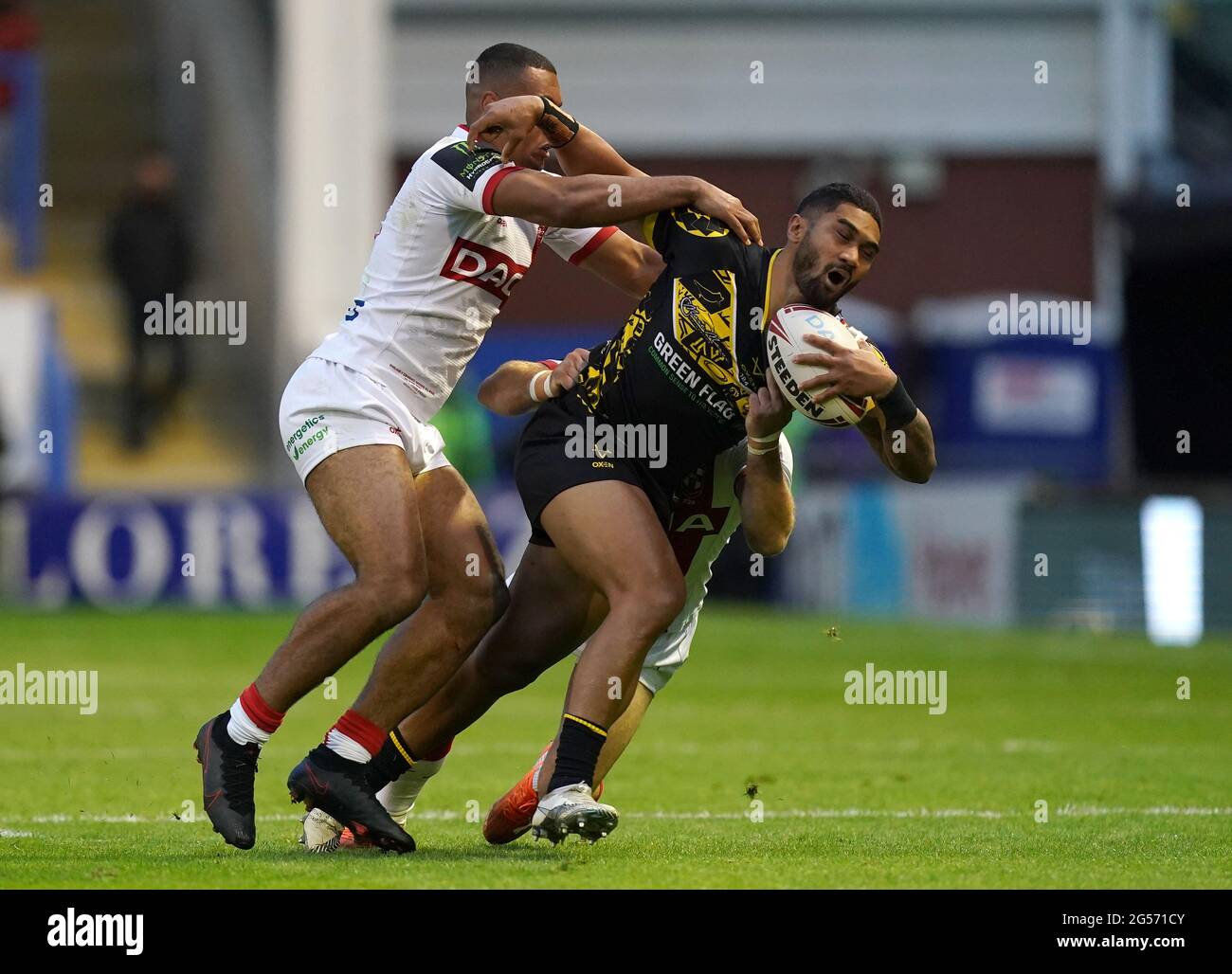 Combined Nations All Stars' Ricky Leutele (a destra) viene affrontato da Reece Lyne (a sinistra) e Luke Gale durante la partita all'Halliwell Jones Stadium di Warrington. Data immagine: Venerdì 25 giugno 2021. Foto Stock